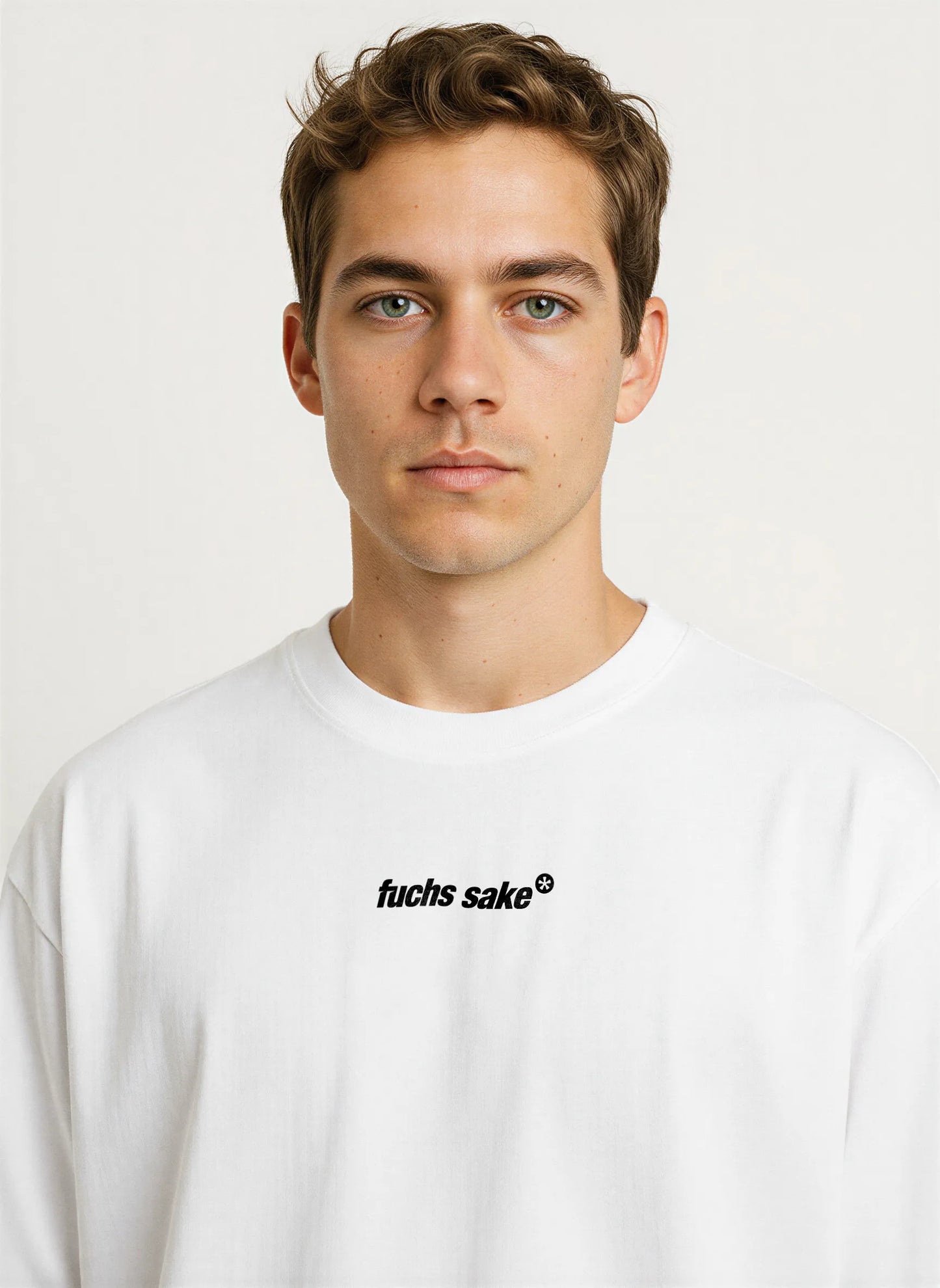 Close-up front view of man wearing white ‘fuchs sake’ T-shirt with small black chest logo — minimalist Porsche-inspired graphic tee