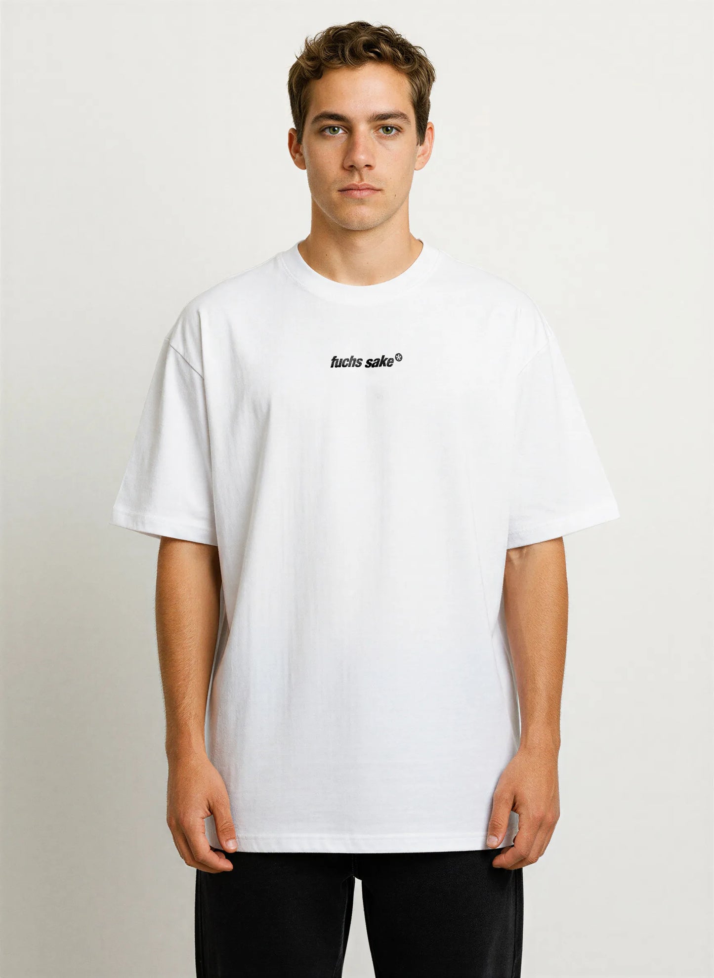 Front view of man modeling clean white T-shirt with small ‘fuchs sake’ logo — premium streetwear with Porsche enthusiast appeal.