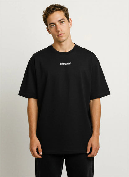 Front view of man modeling black ‘fuchs sake’ T-shirt with minimalist chest logo — premium streetwear for Porsche and Fuchs wheel enthusiasts.
