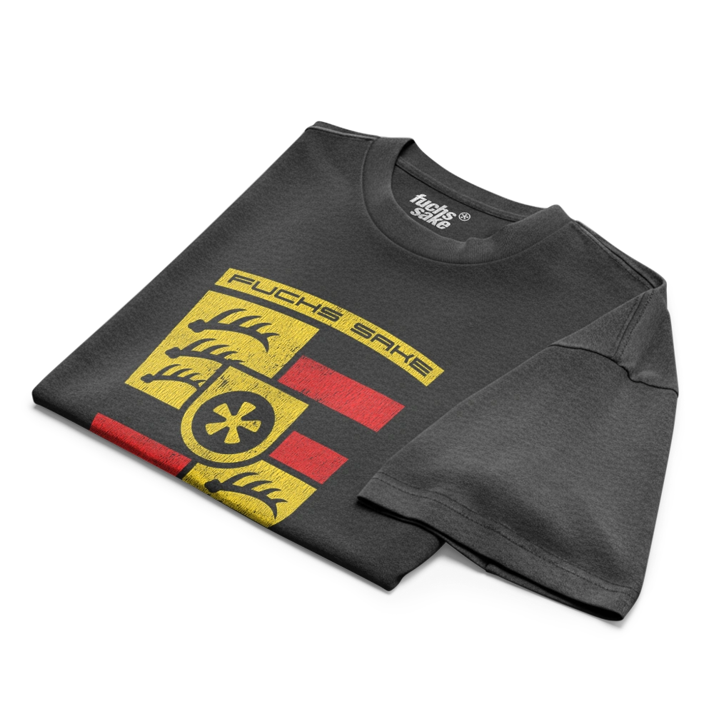 Folded black t-shirt with yellow and red graphic design on a white background