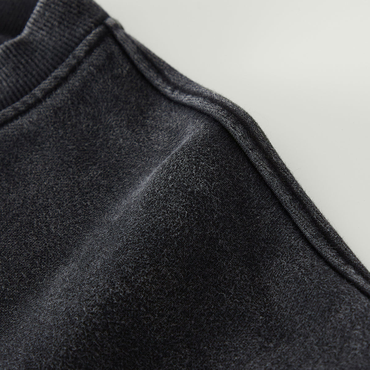 Close-up of dark gray fabric texture on a light gray background