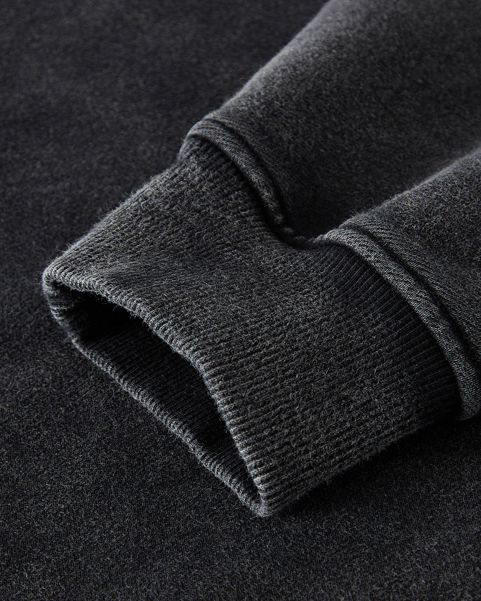 Close-up of a dark gray fleece fabric with a textured surface on a black background
