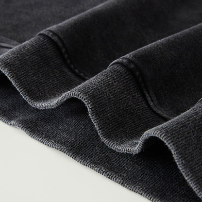 Close-up of dark gray fabric with a textured pattern on a light gray background