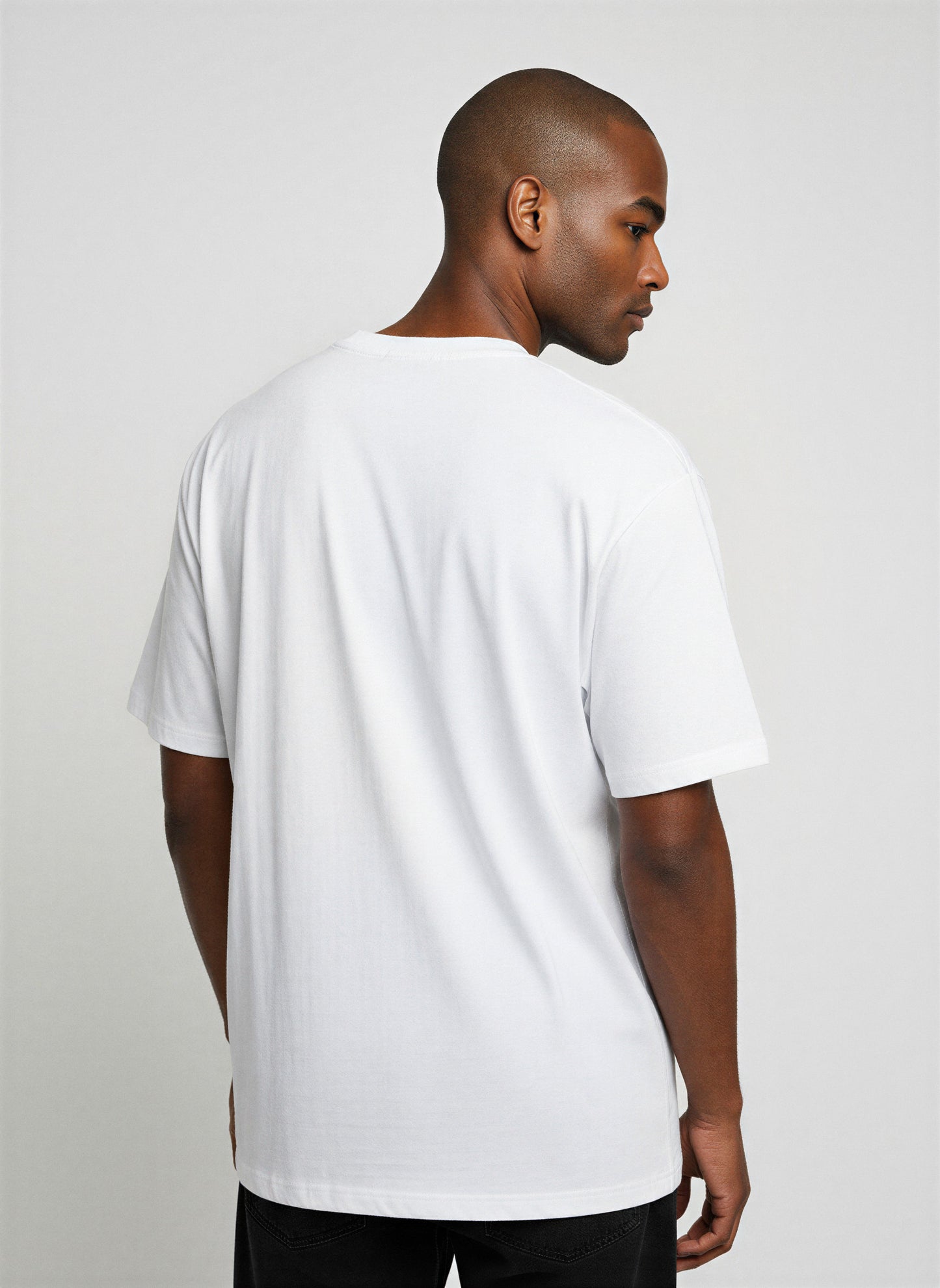 Man wearing a plain white t-shirt against a light gray background