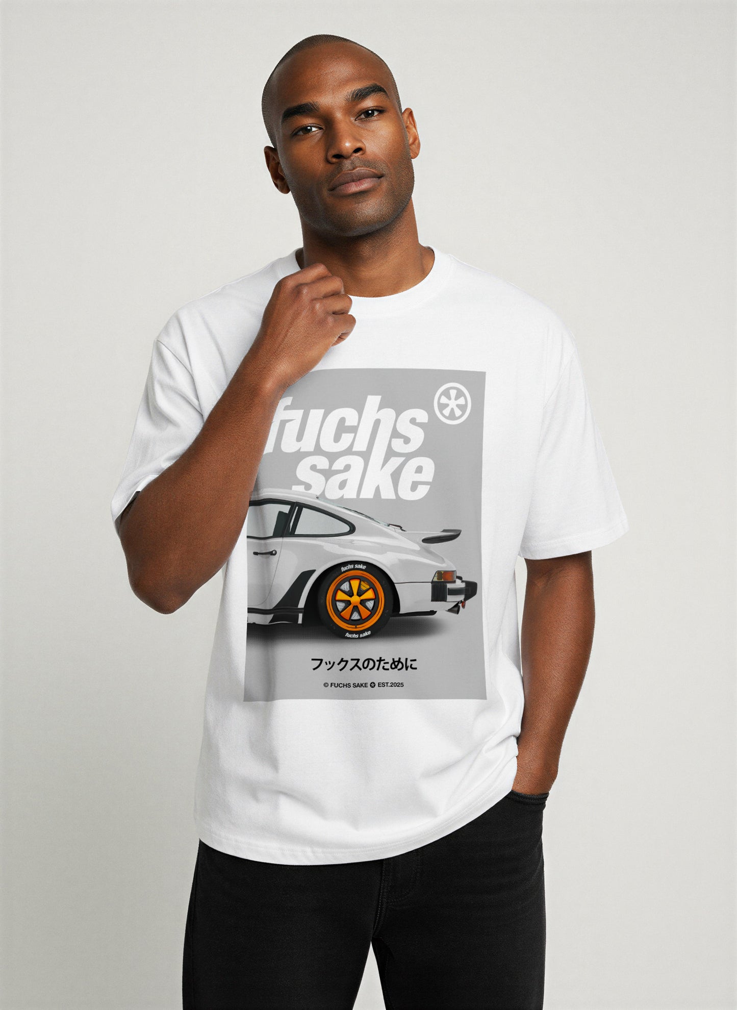 Man wearing white ‘fuchs sake’ T-shirt with Porsche 911 and Fuchs wheel print — premium automotive-inspired streetwear for Porsche lovers.