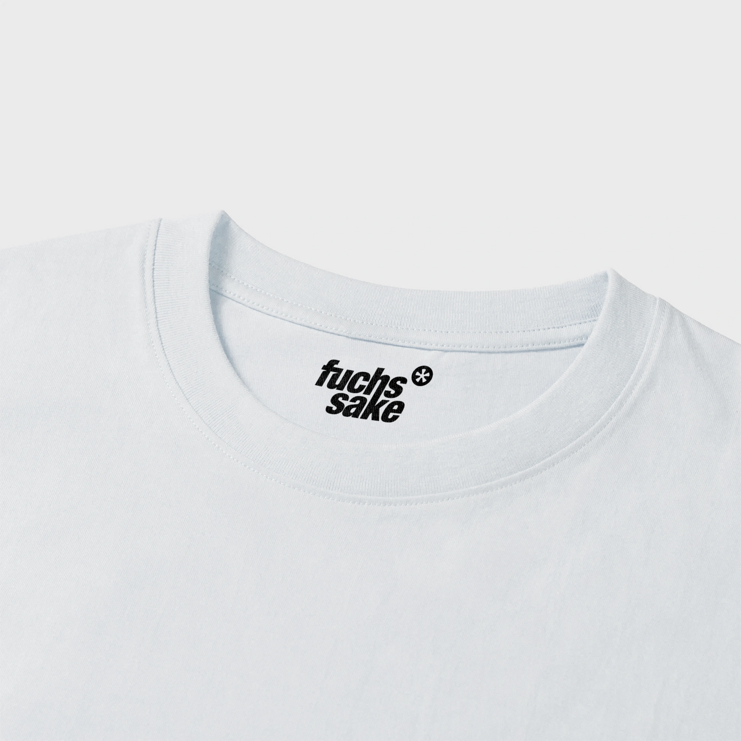 White t-shirt with 'fuchs'sake' logo on a light gray background